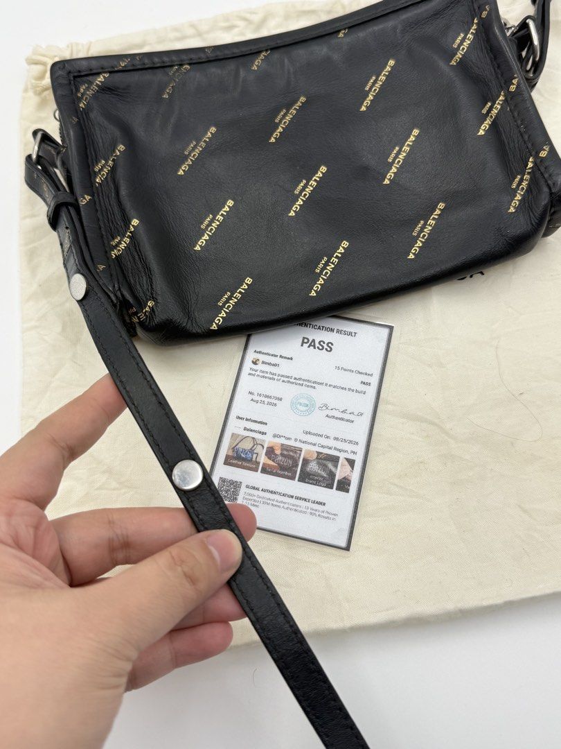 Balenciaga (Category: Cross-body Bags) located in Caloocan City. Submitted by rossvault2 (Listing ID 1465237879, Image 3). Description: - Brand: authentic Balenciaga - Material: Black leather with all-over gold brand logo print - Hardware: Silver-tone with adjustable strap - Closure: Top zip closure - Interior: Card slots and debossed logo branding - Inclusions: Dust bag and authentication certificate included - Condition: Excellent (ready to shi