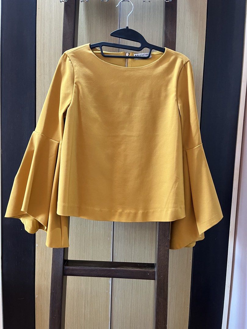 Balenciaga Yellow Blouse (Category: Blouses) located in Muntinlupa City. Submitted by jane226ph (Listing ID 1465204183, Image 1). Description: Brand New •Never used Elegant and timeless piece Sleeves: long with wide, flared bell cuffs Fits : Small to Medium Gifted / Extra Piece No occasion to use, so we’re letting it go. Original purchase details unavailable. Authenticity cannot be independently verified. Sold as-is .