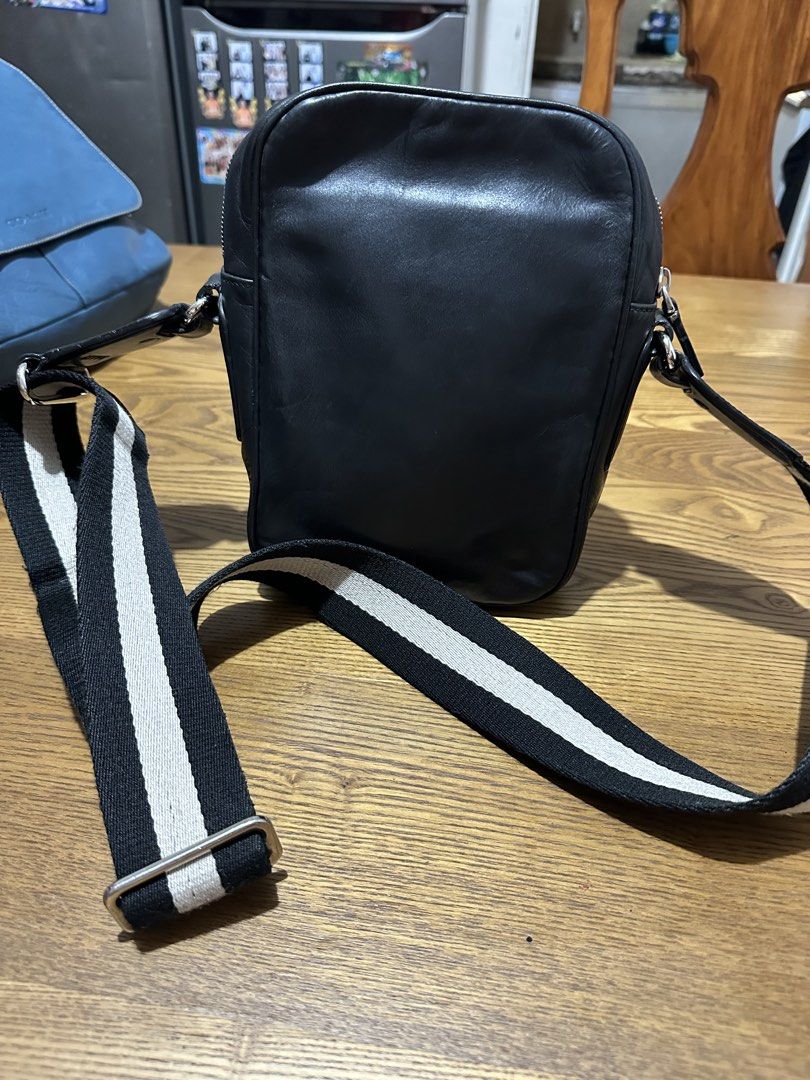 Bally Black Leather Crossbody Bag (Category: Cross-body Bags) located in Quezon City. Submitted by pongoy (Listing ID 1465282987, Image 3). Description: - Brand: Bally - Material: Supple black leather - Design: Structured rectangular shape with contrast stitching and dual metal stud accents - Closure: Secure top zip - Strap: Adjustable black and white striped web strap with silver-toned hardware - Condition: Clean and well-maintained, ideal for e