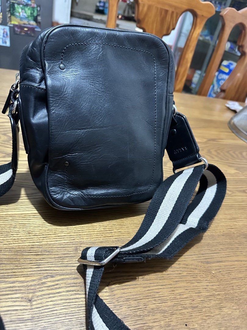 Bally Black Leather Crossbody Bag (Category: Cross-body Bags) located in Quezon City. Submitted by pongoy (Listing ID 1465282987, Image 1). Description: - Brand: Bally - Material: Supple black leather - Design: Structured rectangular shape with contrast stitching and dual metal stud accents - Closure: Secure top zip - Strap: Adjustable black and white striped web strap with silver-toned hardware - Condition: Clean and well-maintained, ideal for e