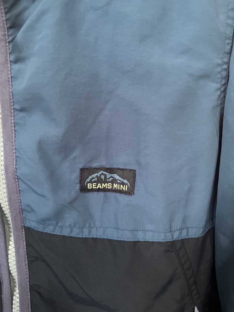 BEAMS mini Colorblocked Windbreaker Jacket Size 140 (Category: Babies & Kids Fashion) located in Tarlac. Submitted by mydeezoo (Listing ID 1465230087, Image 2). Description: - Brand: BEAMS mini - Item: Kids Windbreaker Jacket - Size: 140 - Color: Two-tone blue and dark navy colorblock with purple zipper accents - Lining: Breathable mesh inner lining - Features: Attached hood, front pockets, and adjustable bungee hem drawcords - Material: 100% Nyl