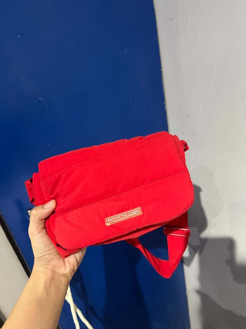 Beyond The Vines Red Puffer Sling Bag (Category: Cross-body Bags) located in Quezon City. Submitted by astargeaaa (Listing ID 1463759194, Image 2). Description: - Brand: Beyond The Vines - Color: Red - Style: Puffer Sling Bag - Material: Soft, lightweight - Features: Adjustable strap, easy to clean - Perfect for: Everyday use, carrying essentials (phone, wallet, keys) - Adds: A pop of color to any outfit.
