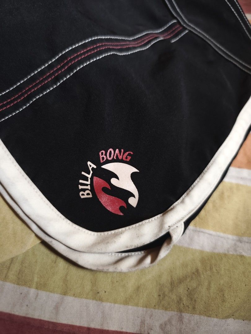 Billabong Black Board Shorts Size 3 (Category: Swim Trunks & Board Shorts) located in Calauag. Submitted by cou1_h (Listing ID 1465338529, Image 3). Description: - Brand: Billabong - Color: Black with pink drawstrings and white piping - Size: 3 (indicated on inner tag) - Material: 100% polyester - Features: Back pocket with snap button closure and logo embroidery on the left leg - Condition: Excellent.