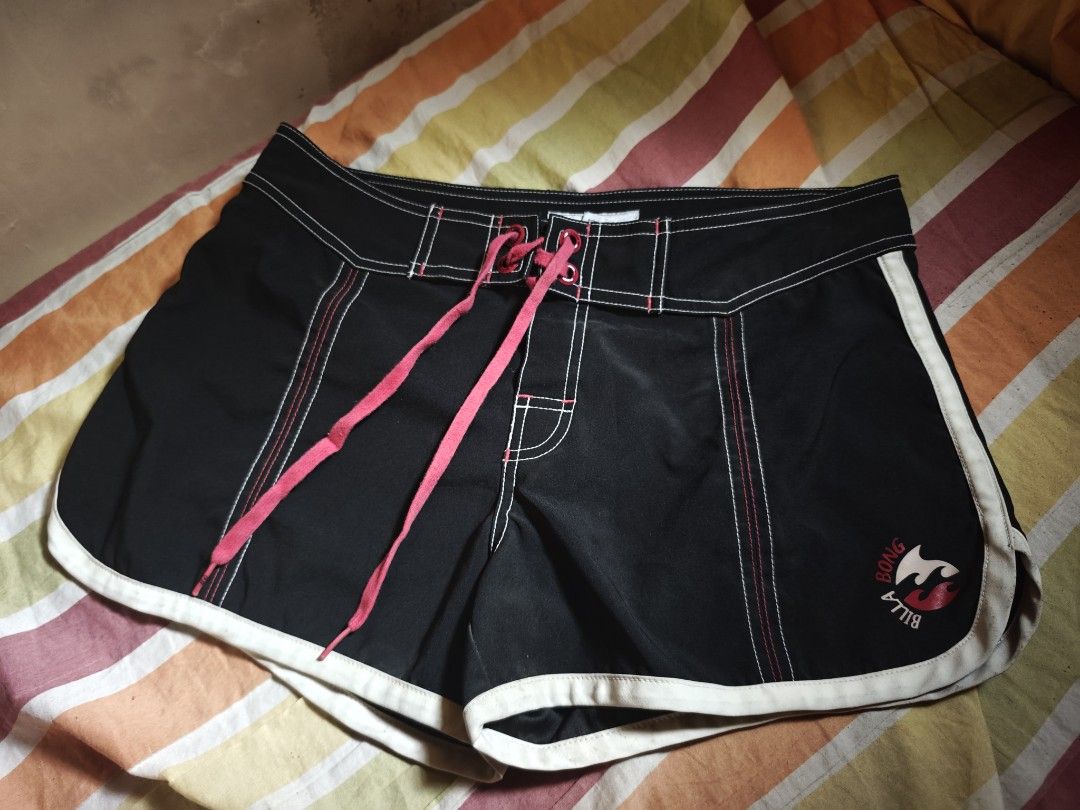 Billabong Black Board Shorts Size 3 (Category: Swim Trunks & Board Shorts) located in Calauag. Submitted by cou1_h (Listing ID 1465338529, Image 2). Description: - Brand: Billabong - Color: Black with pink drawstrings and white piping - Size: 3 (indicated on inner tag) - Material: 100% polyester - Features: Back pocket with snap button closure and logo embroidery on the left leg - Condition: Excellent.