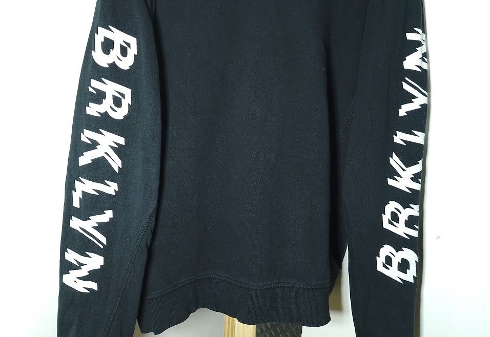 Black BRKLYN Sweatshirt Sleeve Print (Category: Coats, Jackets and Outerwear) located in Manila. Submitted by patrickjos06722 (Listing ID 1465349009, Image 3). Description: - Color: Black with white 'BRKLYN' print on the right chest and both sleeves - Style: Casual crew neck sweatshirt with ribbed cuffs and hem - Size: L/G - Measurements: Pit-to-pit approx. 22 inches, Length approx. 26 inches - Material: Soft and comfortable fabric - Shipping cos