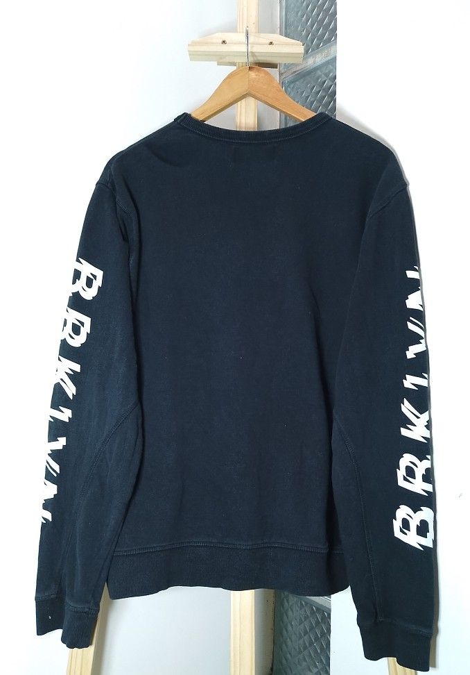 Black BRKLYN Sweatshirt Sleeve Print (Category: Coats, Jackets and Outerwear) located in Manila. Submitted by patrickjos06722 (Listing ID 1465349009, Image 2). Description: - Color: Black with white 'BRKLYN' print on the right chest and both sleeves - Style: Casual crew neck sweatshirt with ribbed cuffs and hem - Size: L/G - Measurements: Pit-to-pit approx. 22 inches, Length approx. 26 inches - Material: Soft and comfortable fabric - Shipping cos
