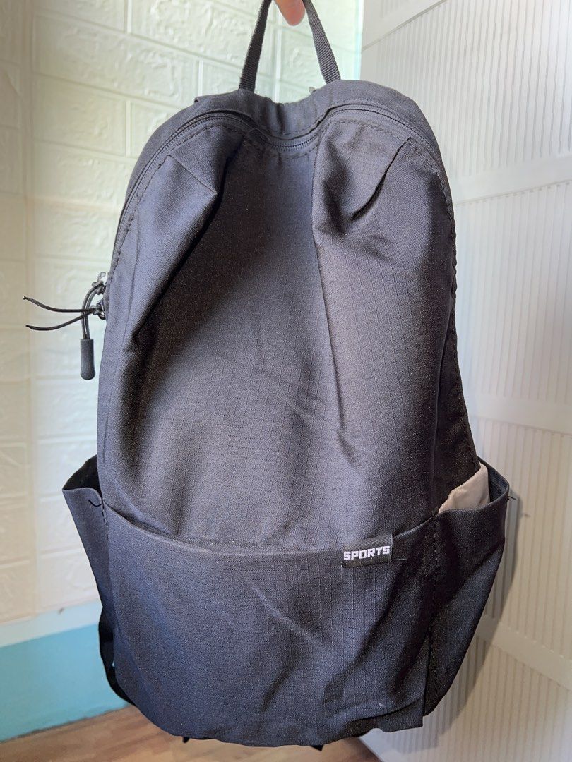 Black Sports Backpack with Adjustable Straps (Category: Backpacks) located in Manila. Submitted by go.kluttery (Listing ID 1465235008, Image 1). Description: - Color: Black with a simple sports label on the front pocket - Closure: Secure top zip closure - Pockets: Convenient side pockets for small water bottles and a built-in inner compartment - Interior: Fully lined in clean grey fabric - Comfort & Carry: Adjustable shoulder straps and a sturdy 