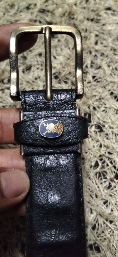 Black Textured Leather Belt with Brass Buckle (Category: Belts) located in Paranaque City. Submitted by michael-08 (Listing ID 1465200587, Image 2). Description: - Color: Black - Material: Genuine leather with heavy pebble grain texture - Hardware: Antique brass-tone metal buckle and single loop keeper - Details: Small circular logo badge on the keeper loop - Fastening: Standard pin buckle with multiple adjustment holes - Style: Classic everyday 