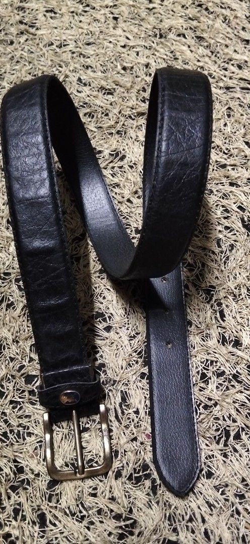 Black Textured Leather Belt with Brass Buckle (Category: Belts) located in Paranaque City. Submitted by michael-08 (Listing ID 1465200587, Image 3). Description: - Color: Black - Material: Genuine leather with heavy pebble grain texture - Hardware: Antique brass-tone metal buckle and single loop keeper - Details: Small circular logo badge on the keeper loop - Fastening: Standard pin buckle with multiple adjustment holes - Style: Classic everyday 