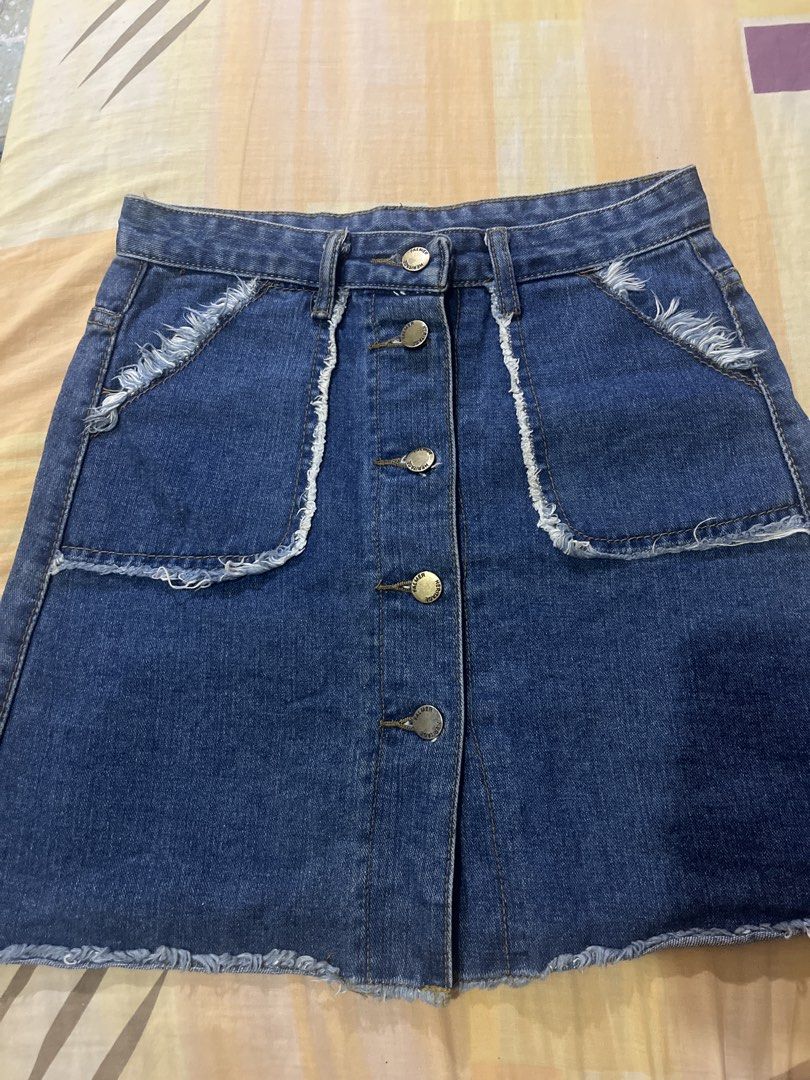 Blue denim mini skirt with front button closure (Category: Skirts) located in Manila. Submitted by pikbit_10231214 (Listing ID 1465327055, Image 1). Description: -Size 28-29 waist - Style: Blue denim mini skirt in a dark wash - Closure: Button-down front with brass hardware - Details: Raw hem at the bottom and raw edges on front pockets - Pockets: Two front pockets and two back patch pockets - Extras: Includes belt loops.
