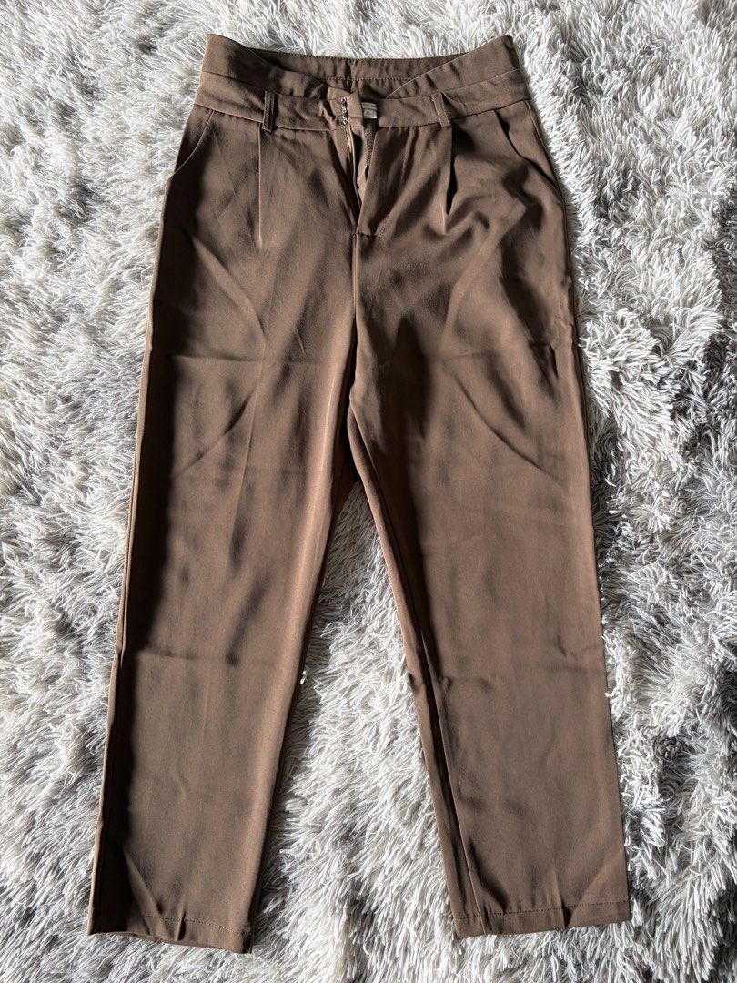 Brown High-Waisted Pleated Tailored Pants (Category: Other Bottoms) located in Manila. Submitted by kez0020 (Listing ID 1465226884, Image 1). Description: - Color: Rich brown - Waist: High-waisted with belt loops and secure zip/hook closure - Details: Front pleats, side pockets, and sharp center creases - Fit: Structured fabric with a clean hem finish - Styling: Perfect match for fitted knit tops or blazers.