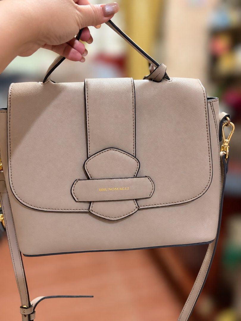 BRUNOMAGLI Beige Leather Shoulder Bag (Category: Shoulder Bags) located in Manila. Submitted by lynnalec25 (Listing ID 1465362662, Image 2). Description: - Brand: Bruno Magli - Color: Neutral beige - Material: Premium leather with clean contrast edge glazing - Design: Structured flap with stylish vertical strap accent and gold-tone lettering - Versatility: Includes a sturdy top handle and a detachable shoulder strap with clasp hardware - Conditio