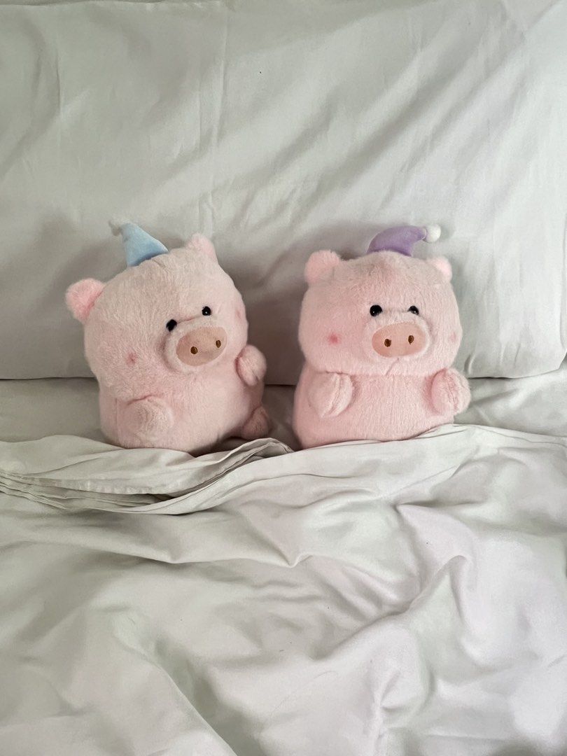 BUNDLE/SET: Cute Pig Plushies with Tiny Sleeping Hats Set of 2 (Category: Plushies & Soft Toys) located in Manila. Submitted by fairybunny13 (Listing ID 1465284459, Image 1). Description: Two adorable pink pig plush toys tucked into white bedsheets. One pig wears a light blue party hat. The other wears a purple sleeping cap with a white pom-pom. Soft fuzzy material with rosy cheeks and little snouts. Selling both together as a pair..