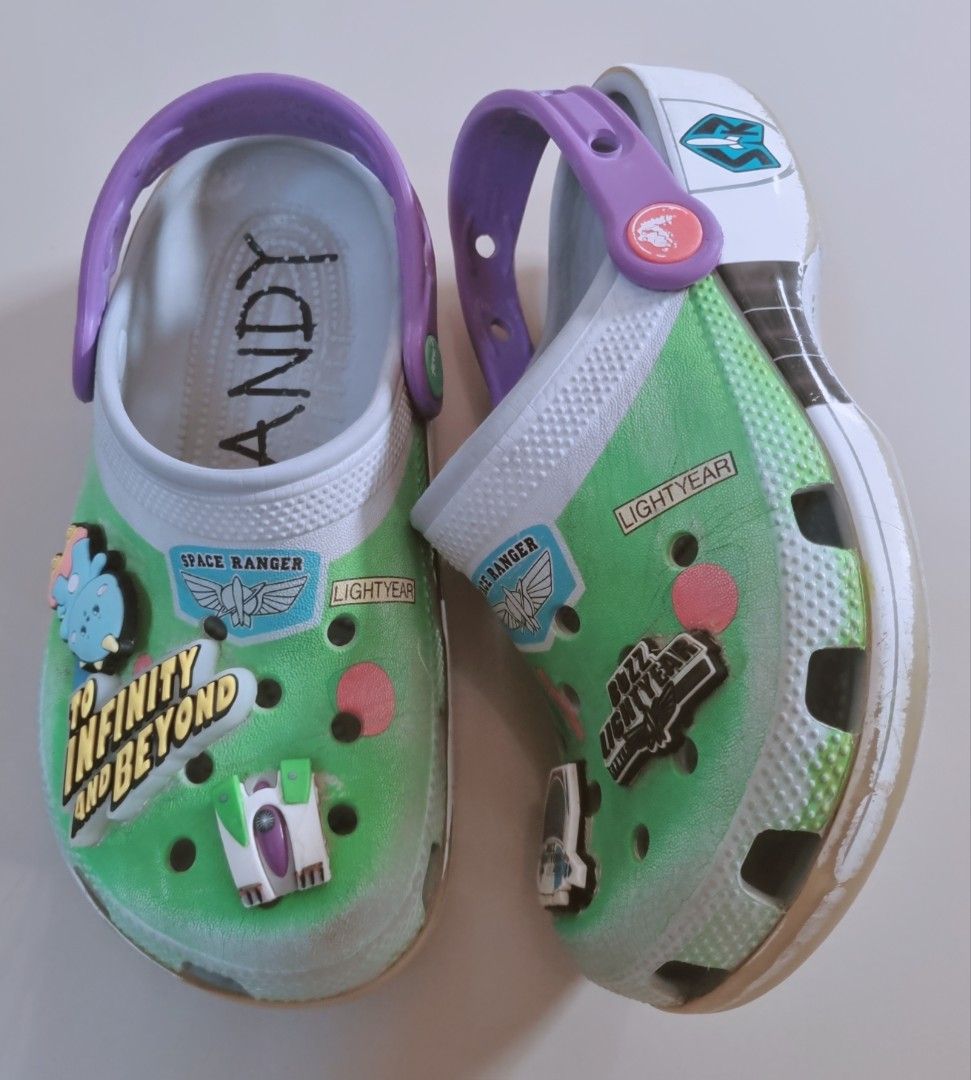 Buzz Lightyear Toy Story Crocs J1 (Category: Babies & Kids Fashion) located in Danao, Cebu. Submitted by CaxeCart (Listing ID 1465224014, Image 1). Description: - Authentic Buzz Lightyear theme Crocs clogs - Iconic green, white, and purple colorway with Toy Story graphics - Classic 'ANDY' signature written inside the left shoe - Comes with extra Jibbitz charms already attached - Cool laser and jet exhaust decals printed on the heels - Comfortable
