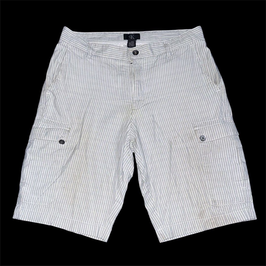 Calvin Klein Striped Cargo Shorts Size 32 (Category: Shorts) located in San Narciso. Submitted by angels.attic21 (Listing ID 1465297647, Image 1). Description: - Calvin Klein Cargo shorts in a subtle khaki and blue pinstripe pattern - Size: 32 - Material: 100% breathable cotton - Features: Multiple pockets including side cargo pockets and buttoned back welt pockets - Branded black front button and subtle logo tag on the back - Great for casual su