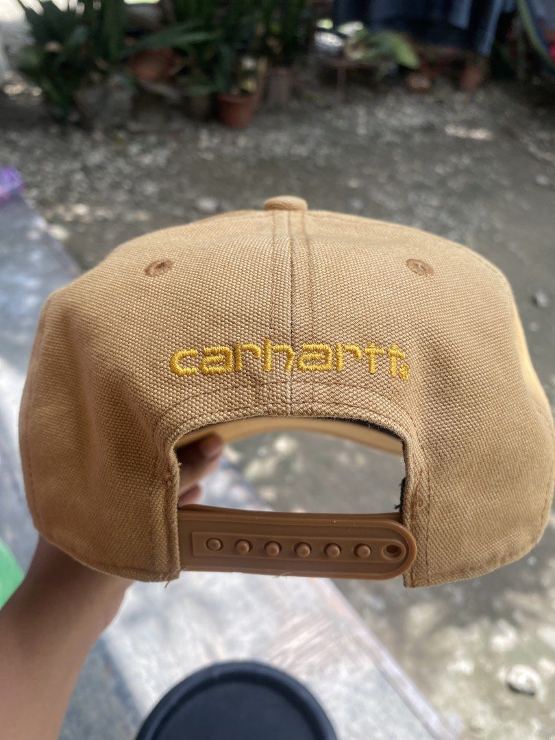 Carhbartt Brown Snapback Cap (Category: Caps & Hats) located in Talisay. Submitted by rjthriftfinds (Listing ID 1465328437, Image 2). Description: - Brand: Carhartt - Style: Canvas snapback cap - Color: Brown - Material: 100% cotton - Details: Classic woven logo patch on front, embroidered lettering above the adjustable snap closure - Interior: Taped seams with brand tags and care label - Origin: Made in China - Condition: Brand new with tags.