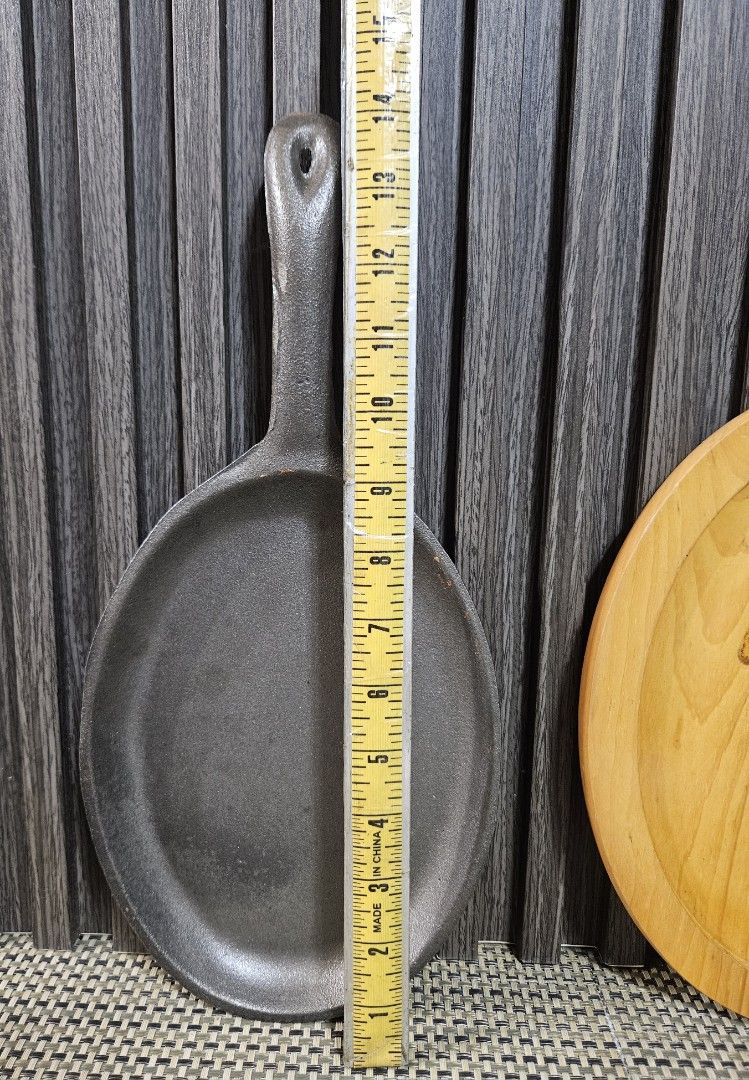 Cast Iron Sizzling Plate with Wooden Base (Category: Cookware & Accessories) located in Rizal. Submitted by cherry_garcia (Listing ID 1465293205, Image 2). Description: Oval cast iron sizzling skillet with matching wooden underliner. Pan measures about 14 inches total length, cooking surface width around 7 inches. Heavy duty construction retains heat well for serving steaks, fajitas, or sizzling dishes right at the table. Wooden base protects tab