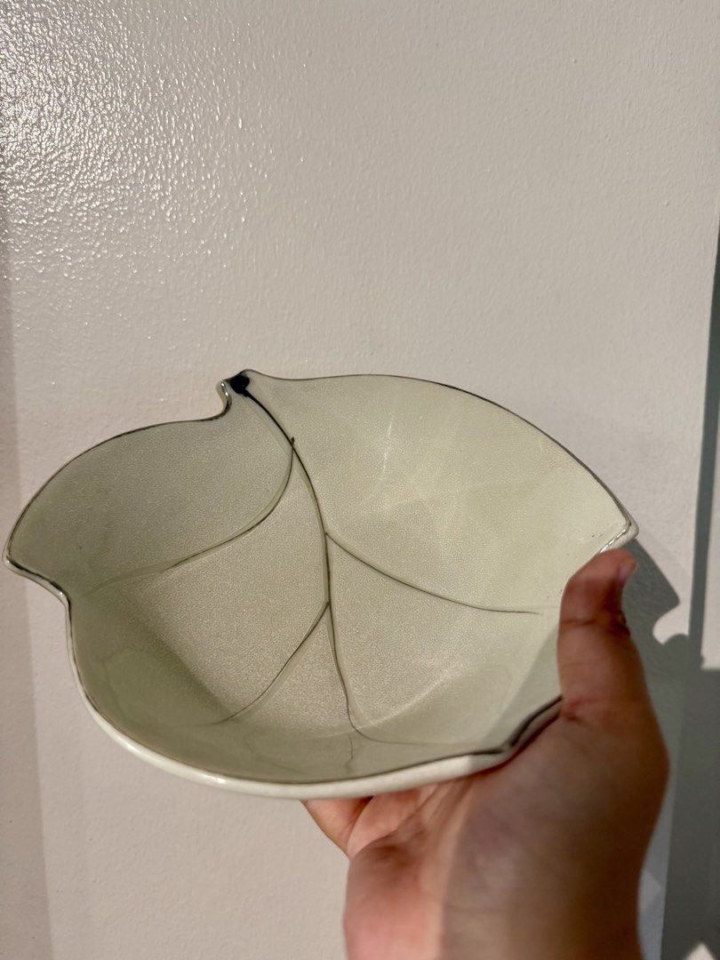 Ceramic Leaf Shaped Decorative Bowl 21cm Length x Width x 6cm Height (Category: Dinnerware & Cutlery) located in Quezon City. Submitted by pamelasal51714 (Listing ID 1465287151, Image 1). Description: - Elegant leaf-shaped ceramic bowl with textured surface and carved vein lines - Stylish white and grey glaze finish accented with a delicate silver rim - Handy size, perfect for holding small trinkets, keys, or serving small snacks - Versatile neut