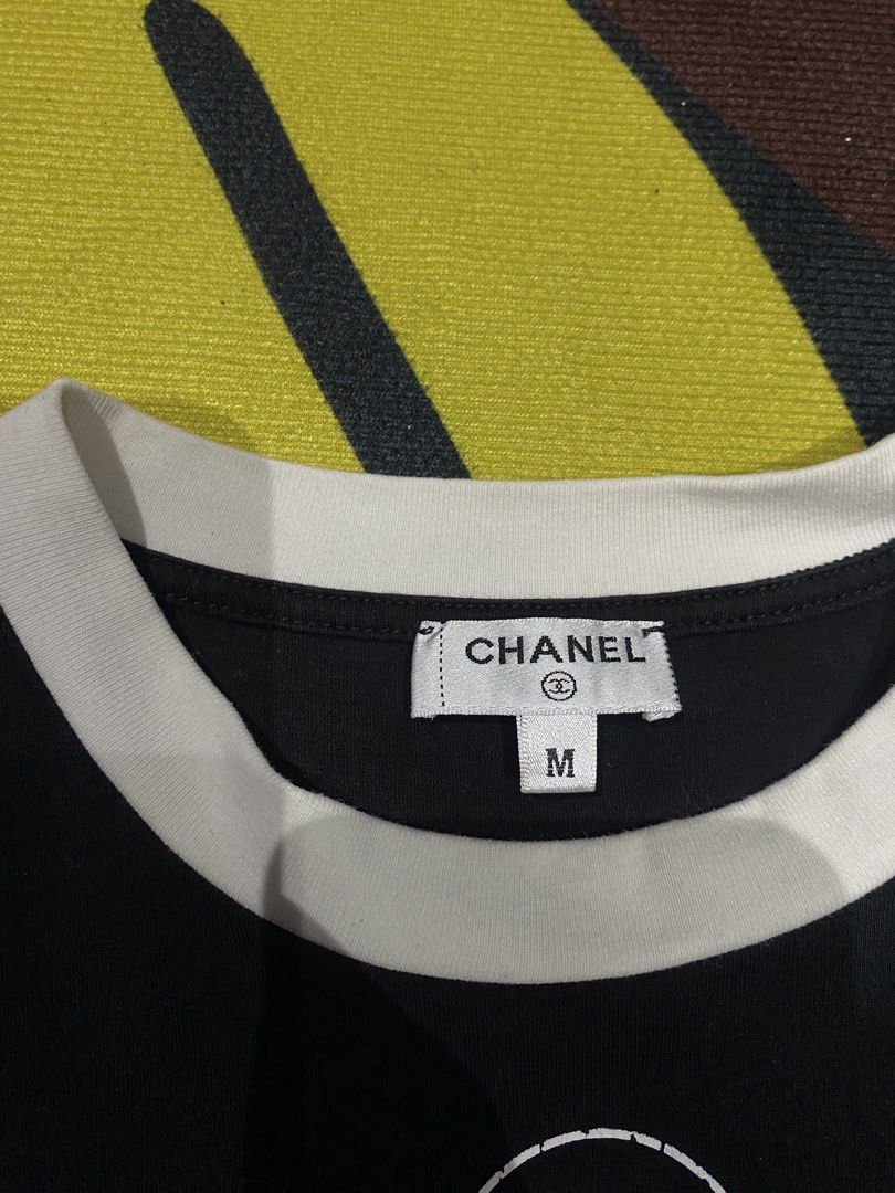 Chanel Black Ringer T-Shirt Size M (Category: Shirts) located in Manila. Submitted by salaspasio80393 (Listing ID 1465284821, Image 3). Description: - Authentic Chanel black cotton t-shirt - Size: Medium (tag attached) - Material: 100% cotton, made in Italy - Design: Contrasting white ringer collar with iconic interlocking CC logo and Chanel lettering on the chest - Fit: Classic casual fit with a clean finish.