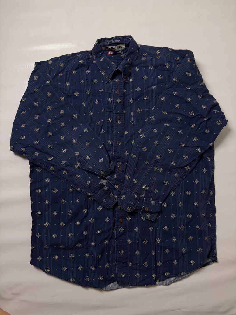 Chaps Ralph Lauren Navy Blue Geometric Pattern Button-Down Shirt (Category: Tshirts & Polo Shirts ) located in Manila. Submitted by johnedel_james (Listing ID 1465280907, Image 2). Description: - Brand: Chaps Ralph Lauren - Color: Navy blue with all-over geometric print and vertical textured stripes - Size: Large (L) - Material: 100% Cotton - Details: Long sleeves with button cuffs, front chest pocket, and brown buttons - Origin: Made in Indonesi