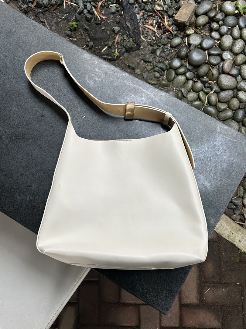 Charles & Keith Off-white shoulder bag with matching pouch (Category: Shoulder Bags) located in Quezon City. Submitted by javi_agbayani (Listing ID 1465221493, Image 2). Description: - Color/Material: Off-white faux leather with contrast beige lining and stitching - Style: Versatile everyday shoulder bag with gold-tone metal hardware and adjustable strap - Includes: A matching small pouch with zip closure - Interior: Unlined with clean contrast d