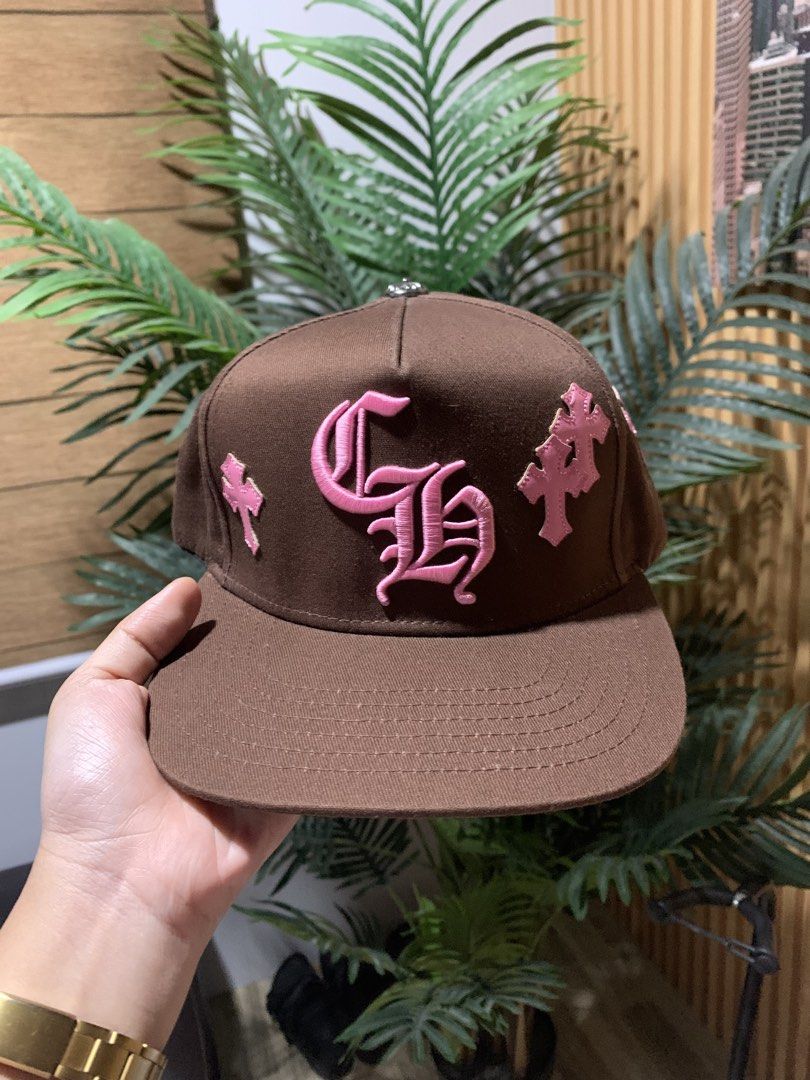 Chrome Hearts Brown Pink Hat Cap (Category: Caps & Hats) located in Butuan. Submitted by nielben13 (Listing ID 1465182984, Image 2). Description: - Brand: Chrome Hearts - Color: Brown with pink embroidery details - Design: Large CH monogram on front, cross patches on sides and back, and lettering above the strap - Hardware: Silver button on top - Structure: Clean fabric with structured panels - Closure: Adjustable snapback - Condition: Excellent,