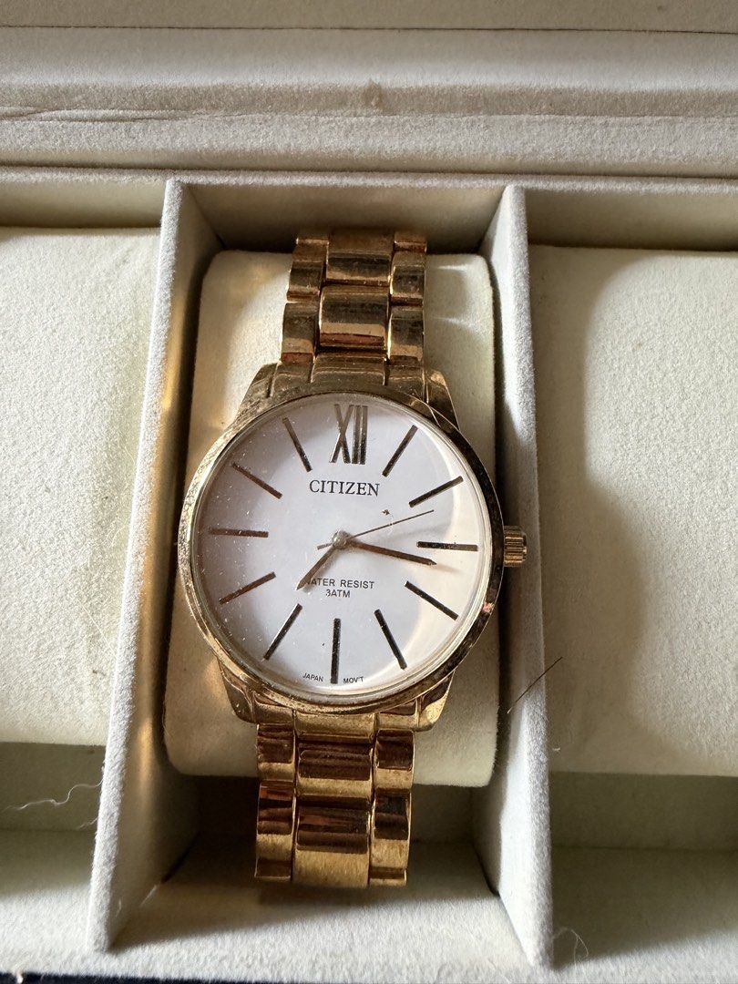 Citizen Gold Tone White Dial Watch (Category: Women's Watches) located in Manila. Submitted by malcolm_169 (Listing ID 1465193761, Image 2). Description: - Brand: Citizen - Design: Elegant gold-tone finish with a white dial, minimalist stick markers, and a classic Roman numeral at 12 o'clock - Movement: Reliable Japanese movement - Durability: Water-resistant up to 3 atmospheres (3 ATM) - Strap: Comfortable metal link bracelet - Inclusion: Comes 