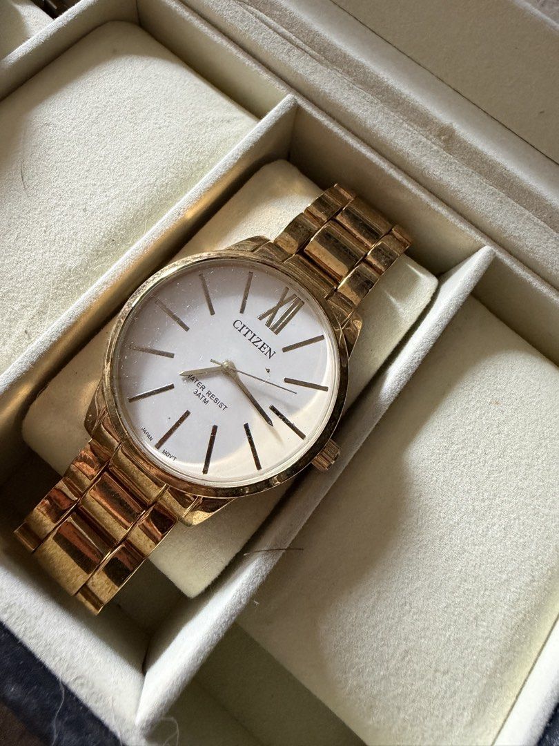 Citizen Gold Tone White Dial Watch (Category: Women's Watches) located in Manila. Submitted by malcolm_169 (Listing ID 1465193761, Image 1). Description: - Brand: Citizen - Design: Elegant gold-tone finish with a white dial, minimalist stick markers, and a classic Roman numeral at 12 o'clock - Movement: Reliable Japanese movement - Durability: Water-resistant up to 3 atmospheres (3 ATM) - Strap: Comfortable metal link bracelet - Inclusion: Comes 