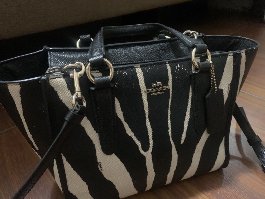 Coach Black and White Zebra Print (Category: Luxury Bags & Wallets) located in Pasig City. Submitted by mmalexinevo (Listing ID 1465320562, Image 2). Description: - Authentic Coach tote bag in a chic black and white zebra pattern - Versatile design with double top handles and a detachable crossbody strap - Secure zip closure with a spacious black fabric interior lining - Elegant gold-tone hardware and iconic Coach metal lettering - Includes origi