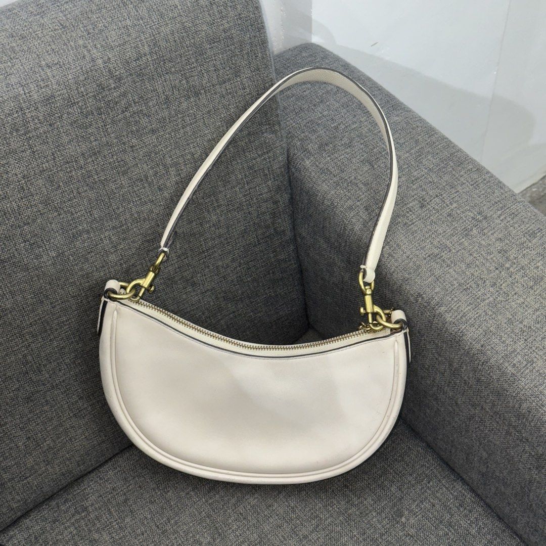 Coach Luna Shoulder Bag Chalk White Leather (Category: Luxury Bags & Wallets) located in Manila. Submitted by wisecloud_1b4b3c (Listing ID 1465266745, Image 2). Description: - Authentic Coach Luna shoulder bag in chalk white smooth leather - Elegant brass hardware and hanging Coach charm - Top zip closure with clean brown fabric lining and creed patch (Style C2457 CM583) - Includes a detachable leather strap for versatile styling - Excellent clea