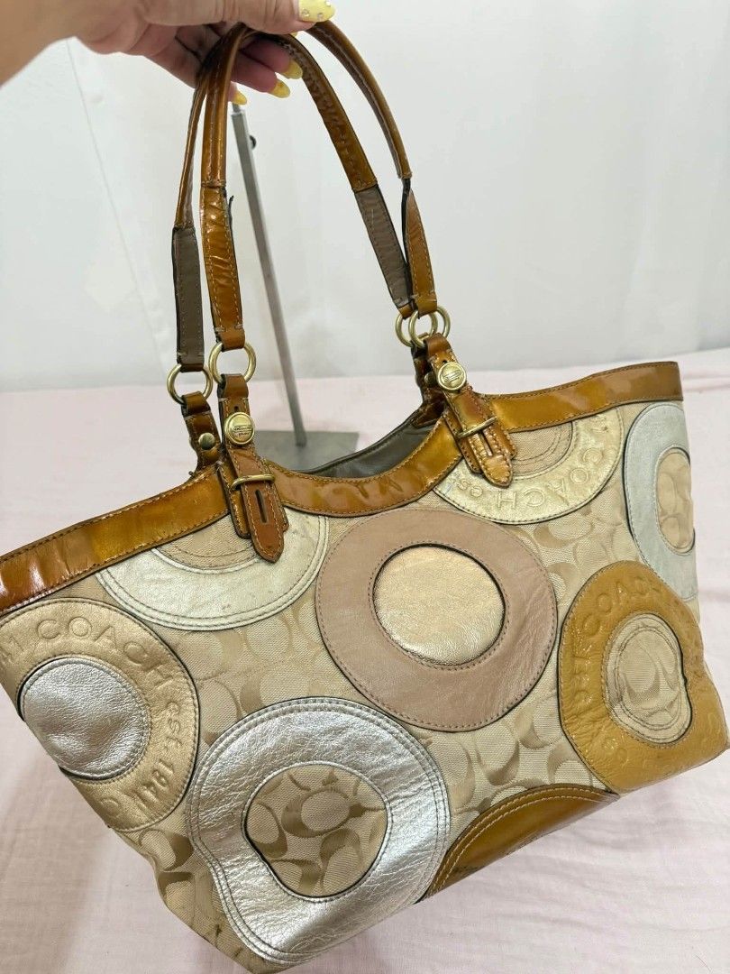 Coach patchwork tote Rank AB (Category: Clutches) located in Manila. Submitted by _louisse (Listing ID 1465350601, Image 2). Description: Coach signature canvas patchwork tote with metallic leather and patent leather trim in shades of brown, gold, and tan. Dual handles with tortoiseshell flower charm accent. Spacious interior lined with fabric. Includes Coach booklet tag as pictured..