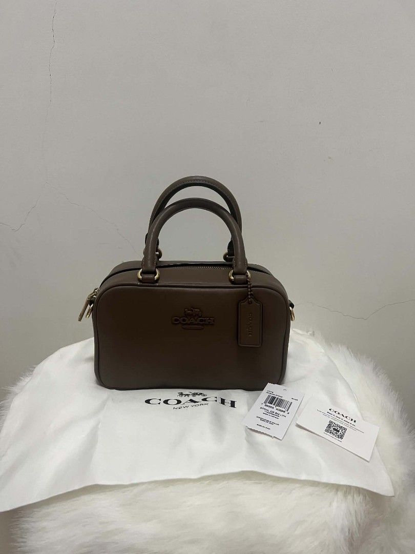 Coach Satchel Sling Bag Dark Stone (Category: Cross-body Bags) located in Paoay. Submitted by rvf1230 (Listing ID 1465189296, Image 2). Description: - Brand: Authentic Coach - Style: Studio Carryall - Color: Dark Stone - Material: Premium Leather - Hardware: Gold-tone - Closure: Secure zip-top - Inclusions: Original white dust bag, hanging leather logo tag, care card, and price tag - Condition: Clean exterior and interior - Size: Great everyday s
