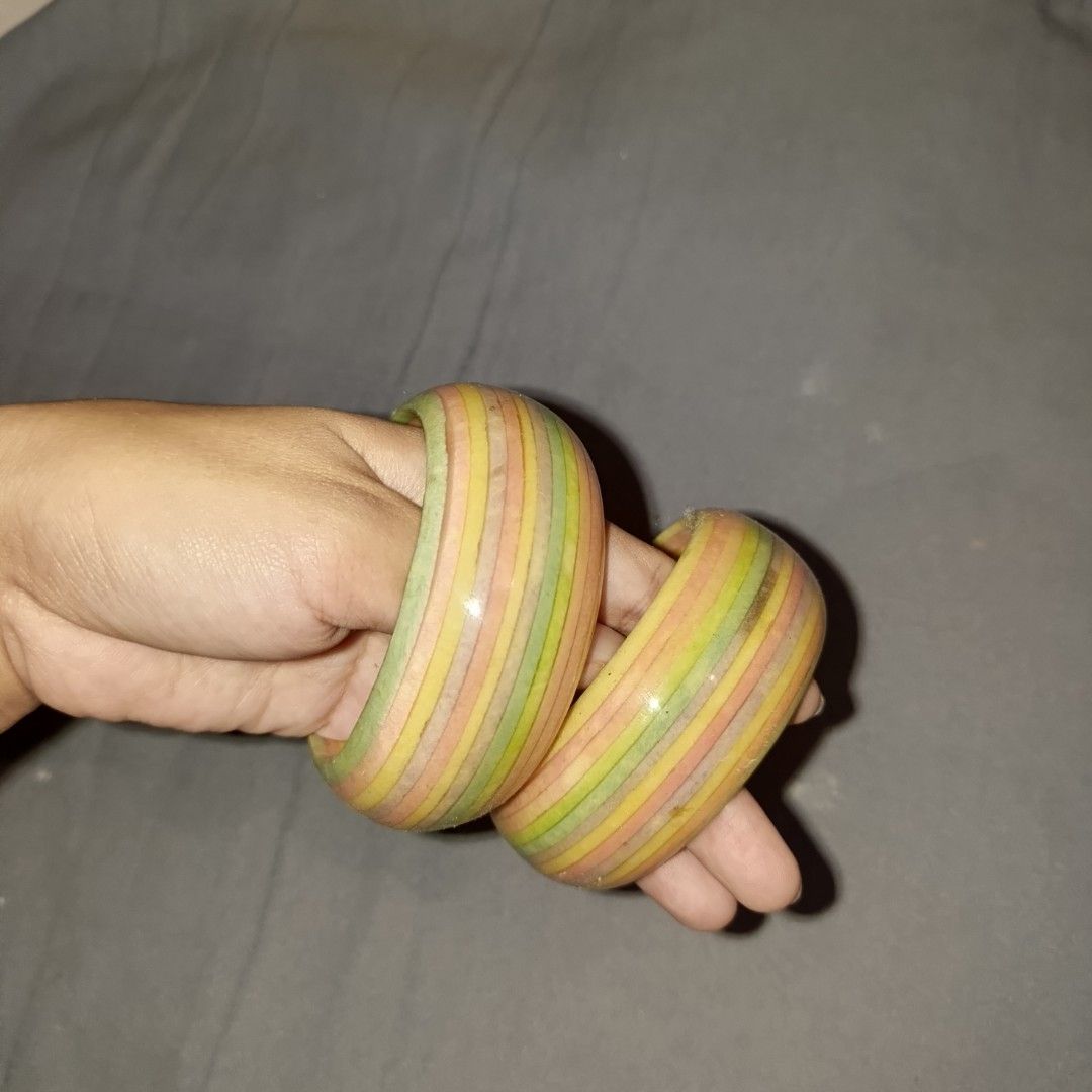 Colorful striped and patterned wooden bangles stack (Category: Bracelets) located in Bulacan. Submitted by snumxxx (Listing ID 1465277043, Image 2). Description: - Variety of thick wooden bangles in vibrant colors and unique patterns - Designs include solid red, solid teal blue, yellow with green triangles, and striped pastel rainbow - Smooth polished finish for comfortable wear - Wear individually for a pop of color or stack together for a bold 