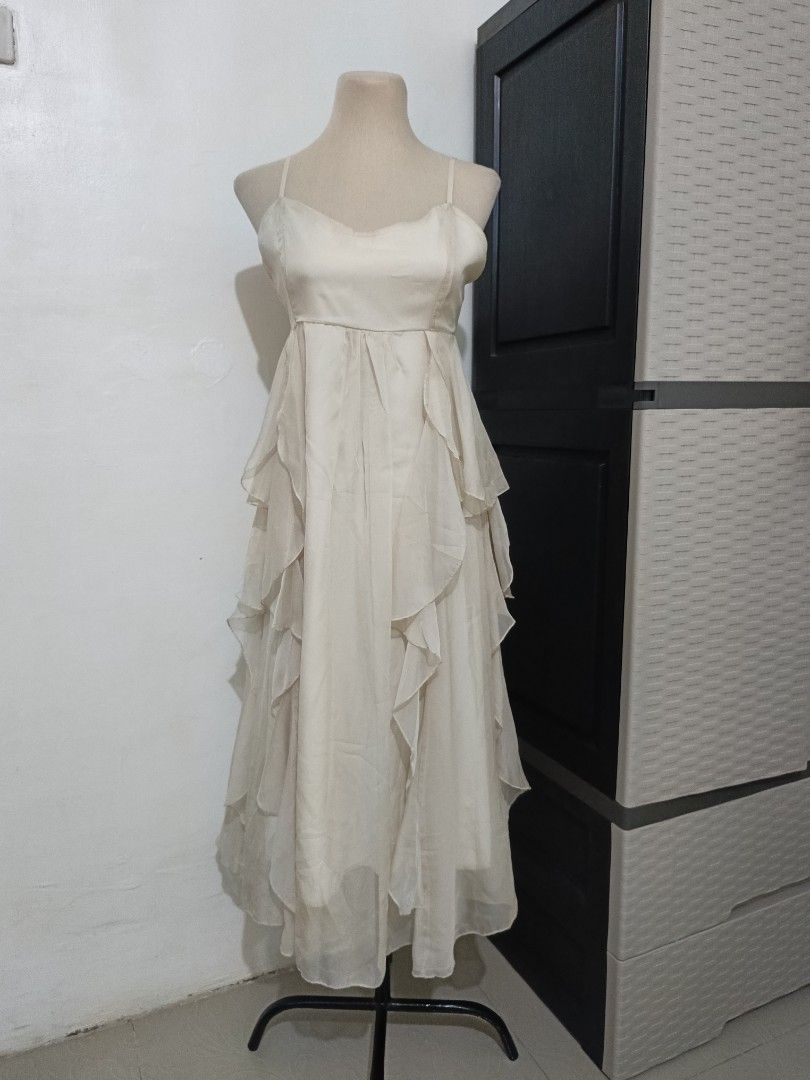 Cream Spaghetti Strap Ruffle Midi Dress (Category: Dresses) located in Cabanatuan. Submitted by lyxyx (Listing ID 1465308097, Image 1). Description: - Color: Cream - Style: Midi dress with spaghetti straps and empire waist - Design: Flowing layered ruffles and trendy handkerchief hem - Material: Lightweight sheer fabric with a solid inner layer - Occasion: Ideal for parties, casual outings, or dinner dates.