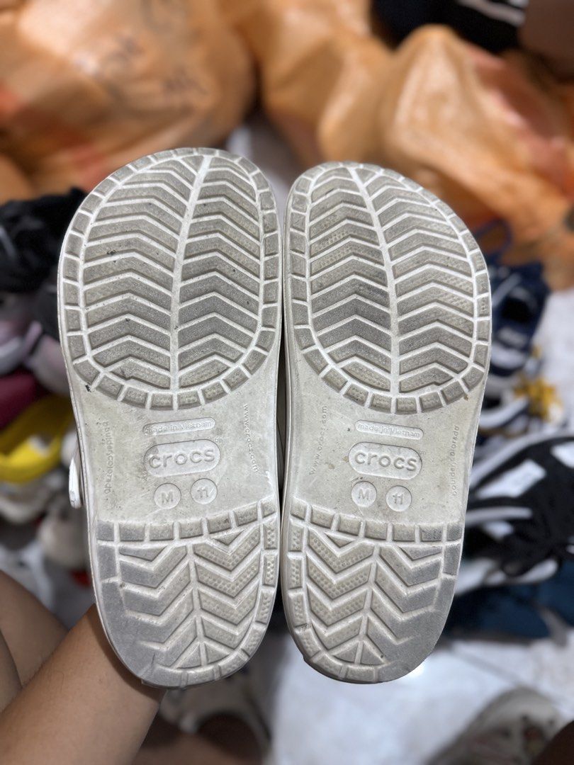 Crocs White Platform Clog Size M11 (Category: Slippers & Slides) located in Bacolod City. Submitted by kitcarsonduff (Listing ID 1465326306, Image 2). Description: - Color: White with black stripe detail along the midsole - Size: M11 (indicated on bottom tread) - Features: Breathable ventilation holes and pivoting heel strap with Crocs branding - Condition: Soles have minor dirt from previous wear, but overall structure is fully intact - Origin: 