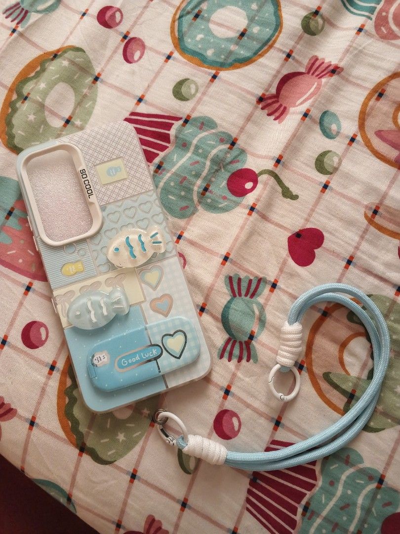 Cute Custom Phone Case (Category: Cases & Sleeves) located in Manila. Submitted by dolleeepaws (Listing ID 1465203599, Image 1). Description: - Color: Pastel blue with charming plaid and heart patterns - Features adorable 3D fish accents and a built-in mirror compartment - Includes a matching blue lanyard for easy carrying - Layered condition: 3 - Meet-up preferred at Zapatera Barangay Hall (Friday to Saturday, 10:00 AM - 1:00 PM).