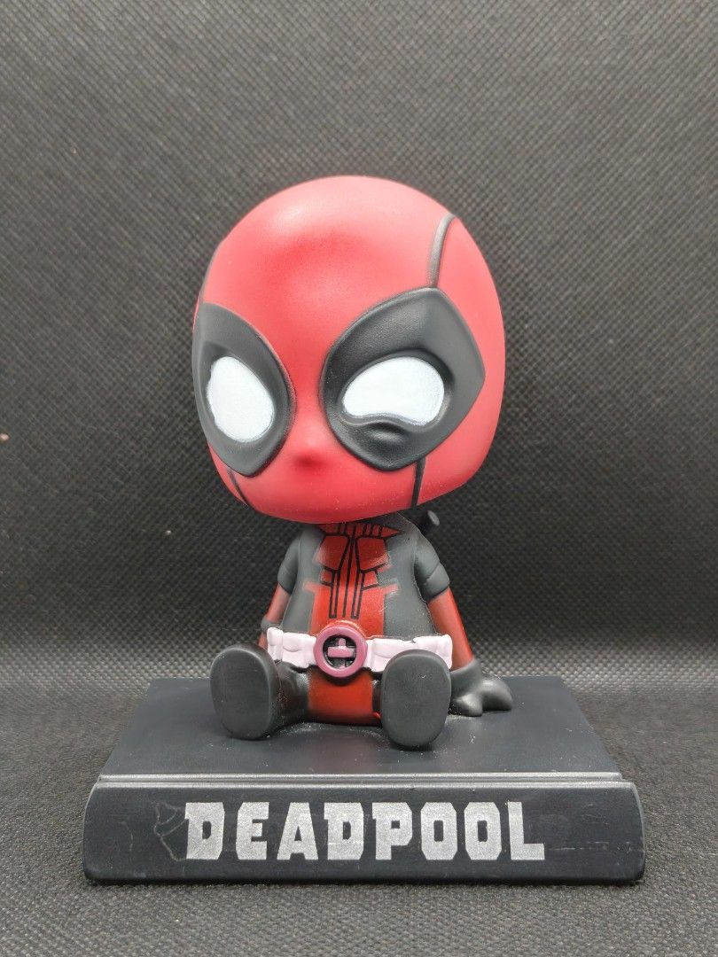 Deadpool Chibi Figurine Sitting on Base (bootleg) (Category: Figurines & Statues) located in Rizal. Submitted by kencamara (Listing ID 1465245956, Image 1). Description: - Adorable chibi-style Deadpool figurine in a sitting pose - Mounted on a custom black display base with 'Deadpool' printed in grey - Classic red and black suit with expressive white eyes and a pink belt buckle - Perfect desktop ornament for Marvel collectors and fans - Stands se
