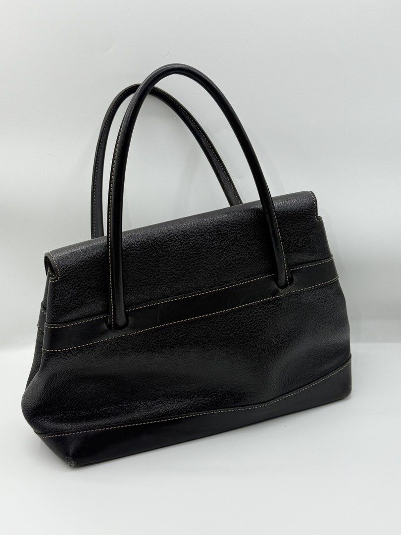 Deux by Delvaux (Category: Tote Bags) located in Caloocan City. Submitted by rossvault2 (Listing ID 1465232493, Image 3). Description: - Brand: Deux by delvaux - Style: Structured black leather tote bag - Material: Pebbled leather body with smooth leather trim - Design details: Contrast stitching along edges and straps, front flap closure with horizontal strap accent and embossed Deux logo - Protection: Metal feet at the bottom - Handles: Dual to