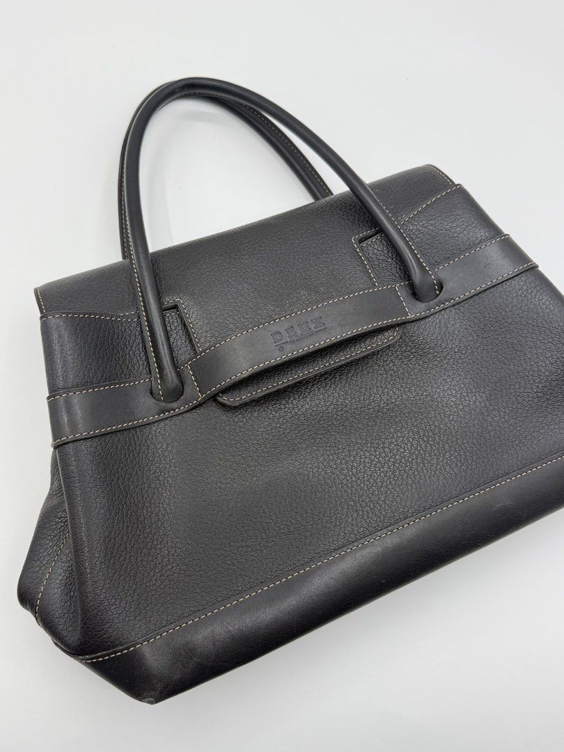 Deux by Delvaux (Category: Tote Bags) located in Caloocan City. Submitted by rossvault2 (Listing ID 1465232493, Image 1). Description: - Brand: Deux by delvaux - Style: Structured black leather tote bag - Material: Pebbled leather body with smooth leather trim - Design details: Contrast stitching along edges and straps, front flap closure with horizontal strap accent and embossed Deux logo - Protection: Metal feet at the bottom - Handles: Dual to