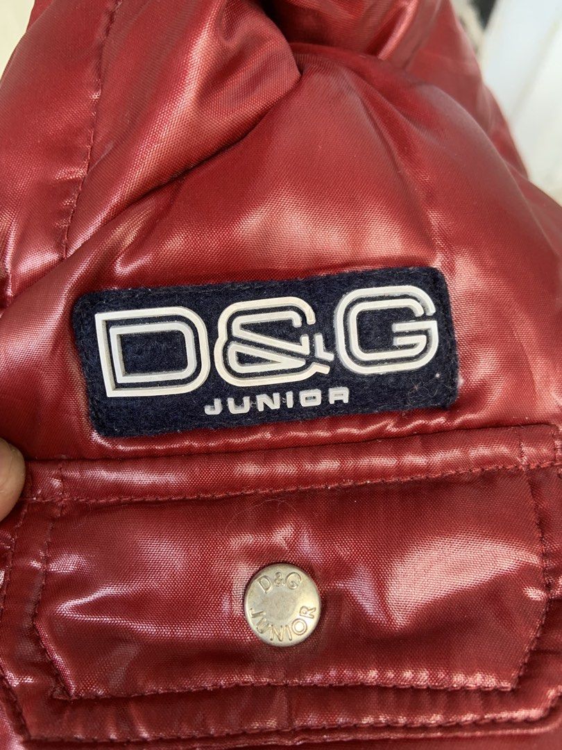 D&G Junior Red Puffer Jacket 6-9 Months (Category: Babies & Kids Fashion) located in Angeles City. Submitted by manlapidma26771 (Listing ID 1465221865, Image 3). Description: - Brand: D&G Junior - Item: Red shiny puffer jacket with hood - Size: 6-9 mesi / 68-74 cm / 26-29 inches - Details: White interior lining, multiple front pockets with silver-toned branded snap buttons, D&G Junior chest logo patch - Condition: Excellent warm winter outerwear 