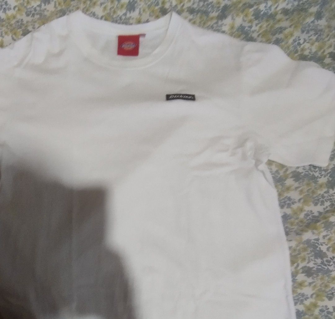 Dickies White T-Shirt Size L (Category: Tshirts & Polo Shirts ) located in Manila. Submitted by lene48 (Listing ID 1465254321, Image 1). Description: - Brand: Dickies - Color: White - Size: L - Material: 100% Cotton - Fit/Style: Standard crew neckline, short sleeves, classic basic tee - Details: Small woven logo on left chest, red neck tag branding - Condition/Vibe: Clean, versatile, and perfect for everyday wear.