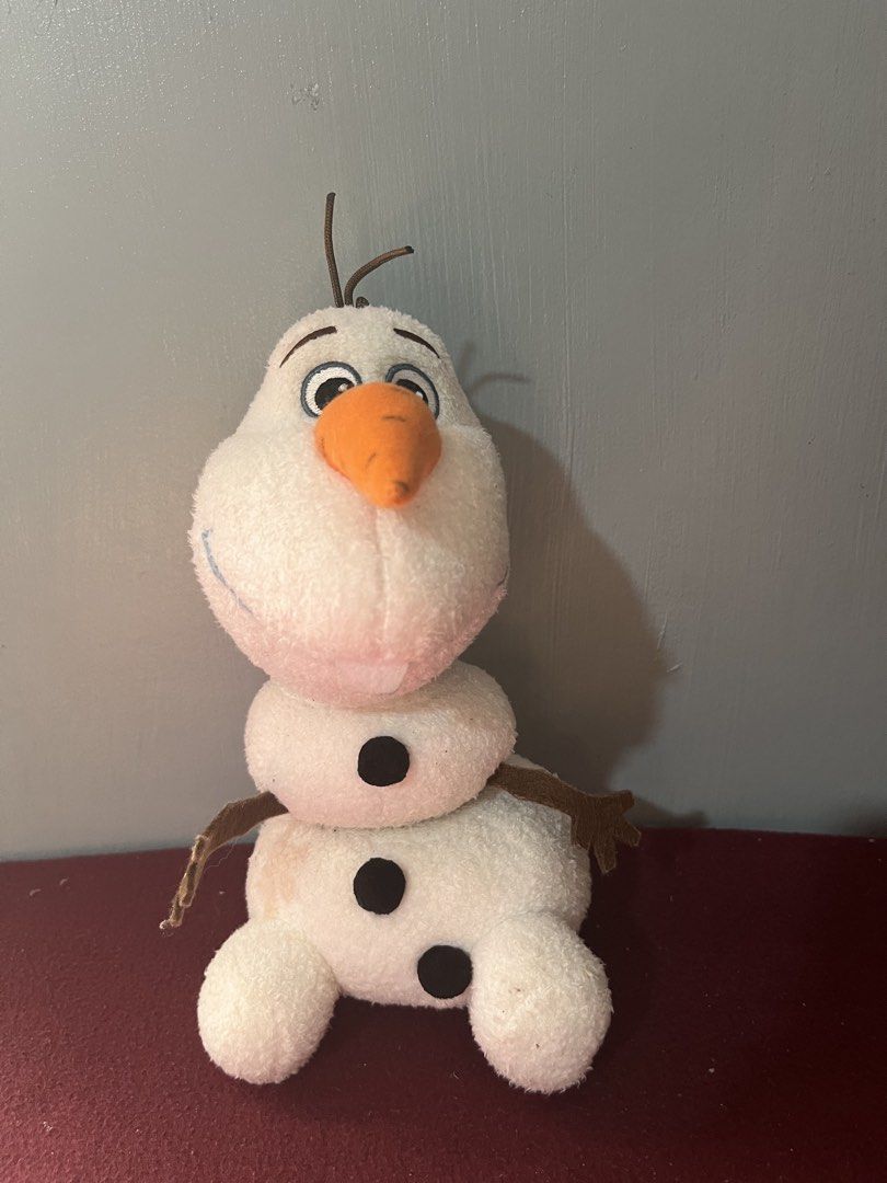 Disney Frozen Olaf Magnetic (Category: Plushies & Soft Toys) located in Baguio. Submitted by gaara1234 (Listing ID 1465195869, Image 1). Description: - Official Disney Frozen Olaf plush toy - Features iconic carrot nose, brown stick arms, and hair - Soft and huggable fabric material - Fun detachable head feature just like in the movie - Sits upright easily on its own - Condition: Shows minor dirt spots from normal handling, still very presentable