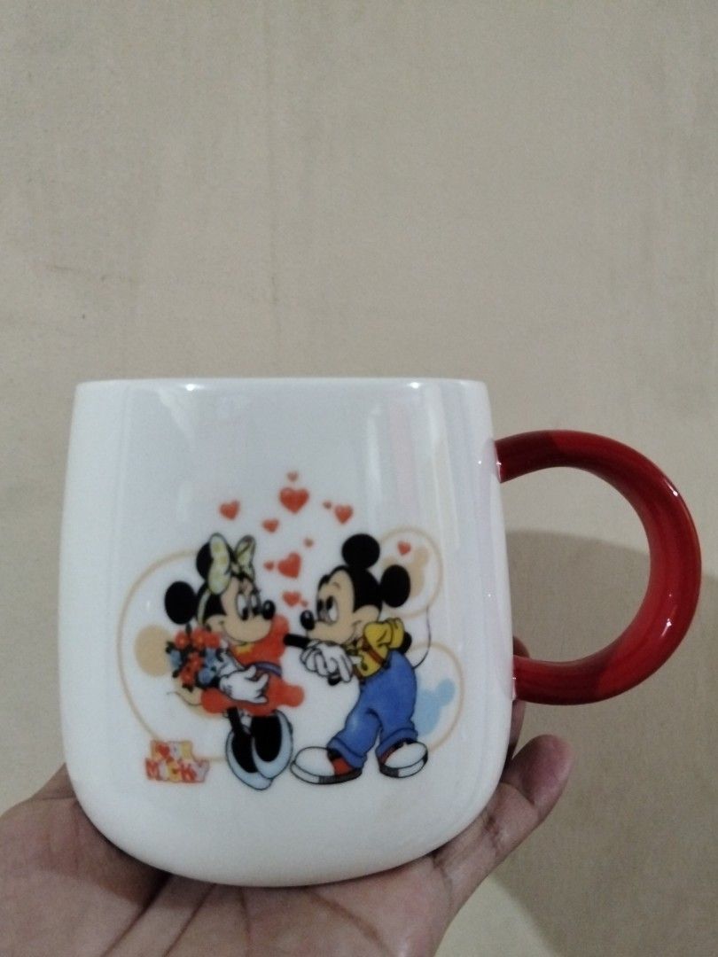 Disney Mickey and Minnie Mouse Ceramic Mug (Category: Coffee & Tea Tableware) located in Caloocan City. Submitted by agr_shop (Listing ID 1465339836, Image 2). Description: - Authentic Disney Mickey & Minnie Mouse graphic print with cute red hearts - Features a bold, contrasting red curved handle for a comfortable grip - Smooth and glossy ceramic finish, easy to wash and clean - Perfect size for your morning coffee, tea, or hot chocolate.