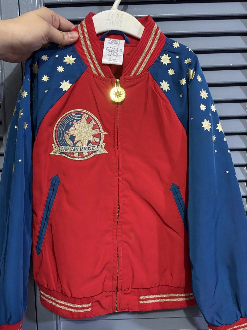 Disney Parks Captain Marvel Bomber Jacket Size 5/6 (Category: Babies & Kids Fashion) located in Quezon City. Submitted by pjr15 (Listing ID 1465210310, Image 1). Description: - Authentic Disney Parks Captain Marvel bomber jacket - Size: 5/6 (fits up to 116 cm height) - Design: Red body with blue sleeves and all-over gold star prints - Details: Large embroidered star patches on front and back, gold star zipper pull, and metallic gold-striped ribbe