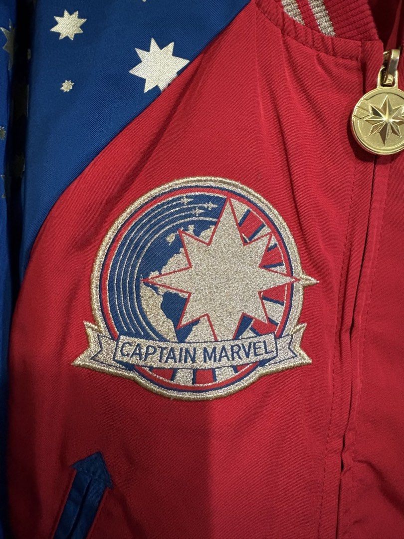 Disney Parks Captain Marvel Bomber Jacket Size 5/6 (Category: Babies & Kids Fashion) located in Quezon City. Submitted by pjr15 (Listing ID 1465210310, Image 3). Description: - Authentic Disney Parks Captain Marvel bomber jacket - Size: 5/6 (fits up to 116 cm height) - Design: Red body with blue sleeves and all-over gold star prints - Details: Large embroidered star patches on front and back, gold star zipper pull, and metallic gold-striped ribbe