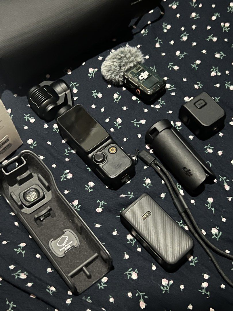 DJI Osmo Pocket 3 Creator Combo (Category: Cameras) located in Manila. Submitted by jacobtesto52166 (Listing ID 1465305714, Image 3). Description: DJI Osmo Pocket 3 Creator Combo package. Includes the camera itself, protective carrying case, mini tripod, DJI Mic 2 transmitter with deadcat wind muff, battery handle, and wide-angle lens attachments in the storage case. Original retail box included. Everything laid out ready for vlogging or video pr