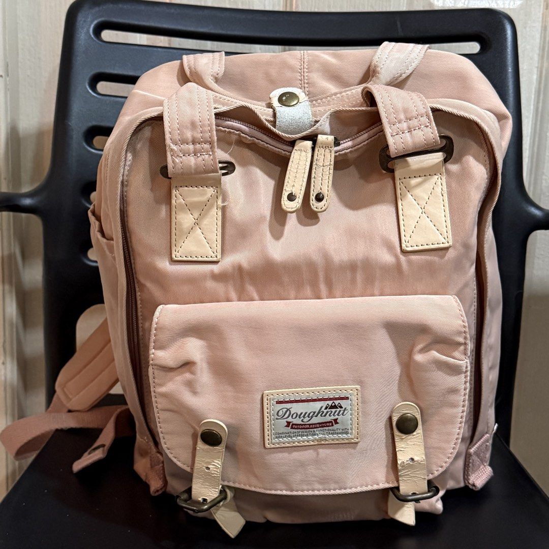 Doughnut Macaroon Backpack Pink (Category: Backpacks) located in Makati City. Submitted by julyco. (Listing ID 1465357435, Image 1). Description: - Brand/Model: Doughnut Macaroon Backpack - Color: Dusty Pink with Cream Leather Accents - Material: Durable Nylon Fabric with Metal Hardware - Storage: Main dual-zipper closure, front zipped compartment, and side pockets - Features: Top carrying handles with snap button tab and adjustable back straps -