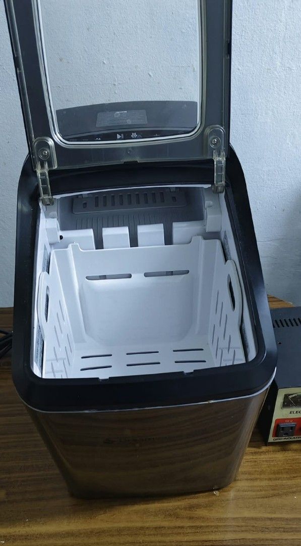 Dreamiracle IM2200-UL Countertop Ice Maker (Category: Refrigerators and Freezers) located in Taguig. Submitted by thrifthub.ph (Listing ID 1465213436, Image 3). Description: Dreamiracle IM2200-UL countertop ice maker. Stainless steel finish with black accents and a clear viewing window on top. Includes removable white plastic ice basket inside. Built-in cooling fan and power cord at the back. Manufactured May 2021. Operates on 120V AC. Powers on 