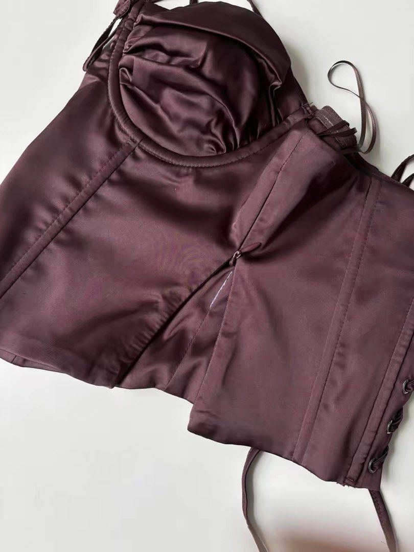 Edikted Satin Corset Top in Plum (Category: Sleeveless) located in Quezon City. Submitted by shoppingspreewithme (Listing ID 1465222806, Image 3). Description: - Color: Plum - Material: Smooth satin with a slight sheen and inner lining - Support: Structured underwire cups with gathered fabric - Closure: Side zipper and adjustable lace-up back with silver-tone metal eyelets - Fit: Cropped length with a flattering dipped hem.