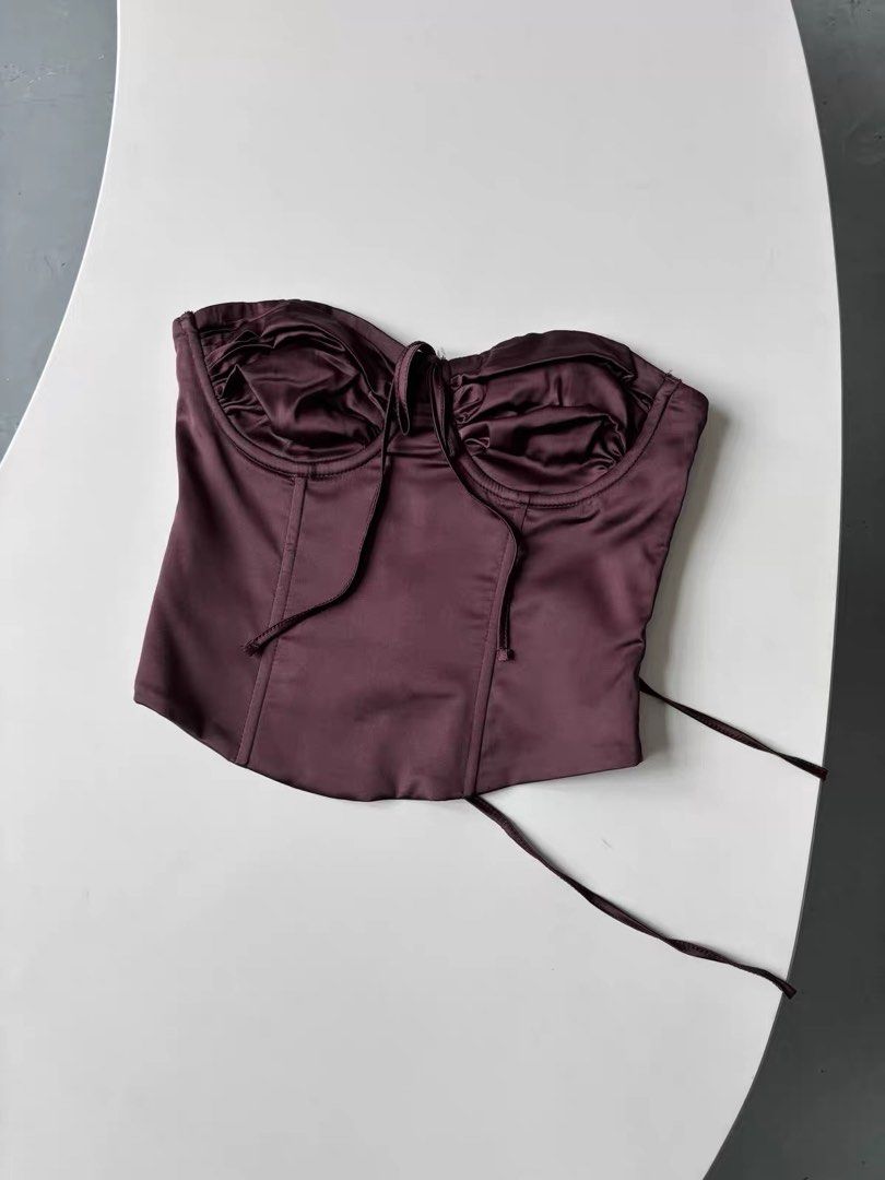 Edikted Satin Corset Top in Plum (Category: Sleeveless) located in Quezon City. Submitted by shoppingspreewithme (Listing ID 1465222806, Image 2). Description: - Color: Plum - Material: Smooth satin with a slight sheen and inner lining - Support: Structured underwire cups with gathered fabric - Closure: Side zipper and adjustable lace-up back with silver-tone metal eyelets - Fit: Cropped length with a flattering dipped hem.